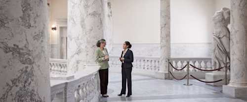 Two government employees meet to discuss FedRAMP solutions