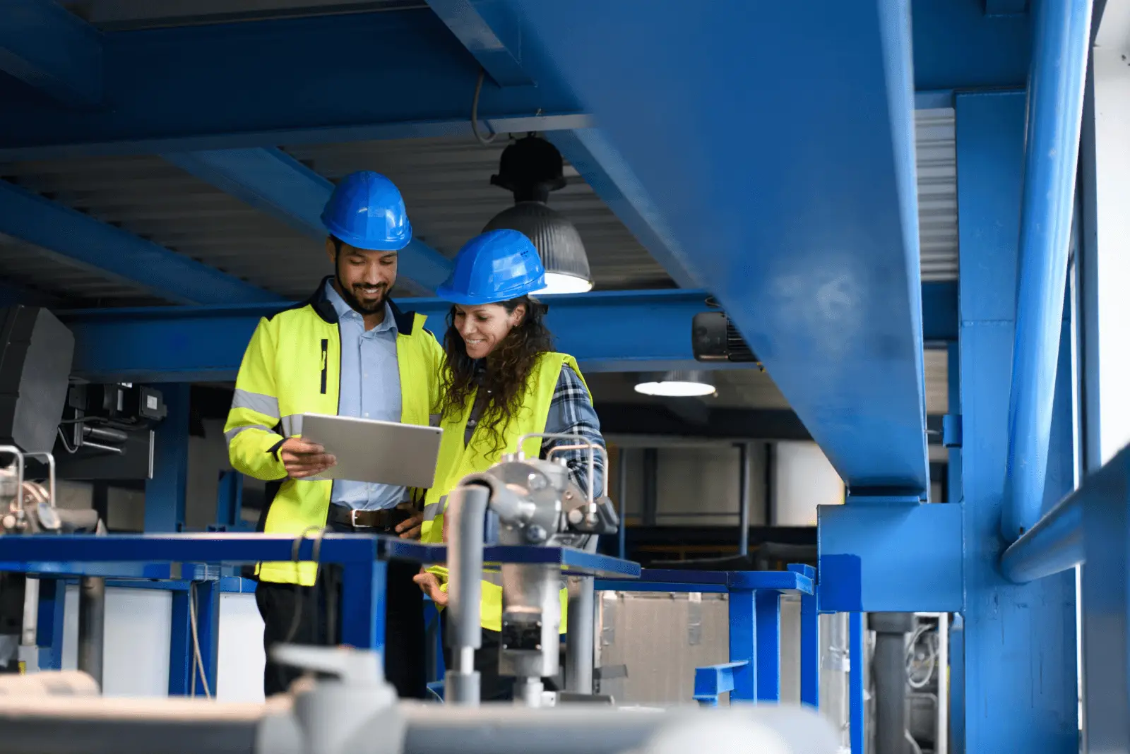 Two construction workers review forms on a tablet