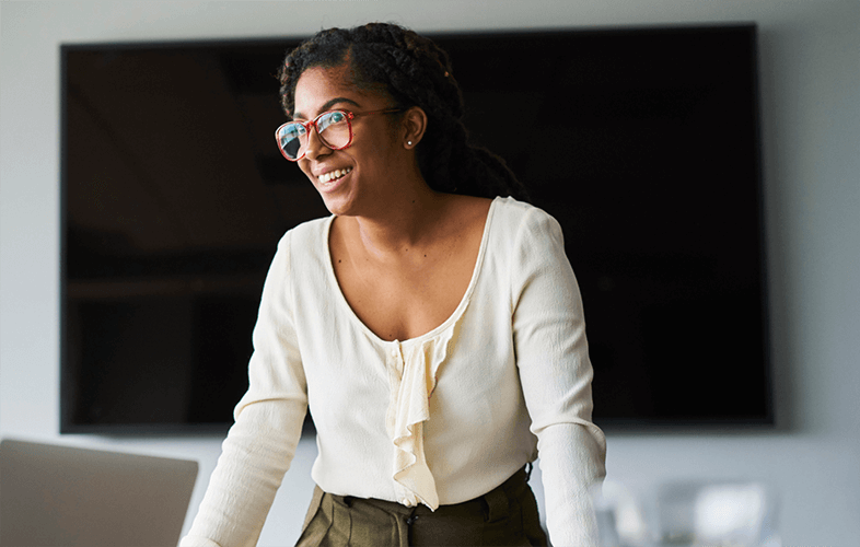 Una sonriente mujer de negocios con lentes durante una presentación de trabajo.