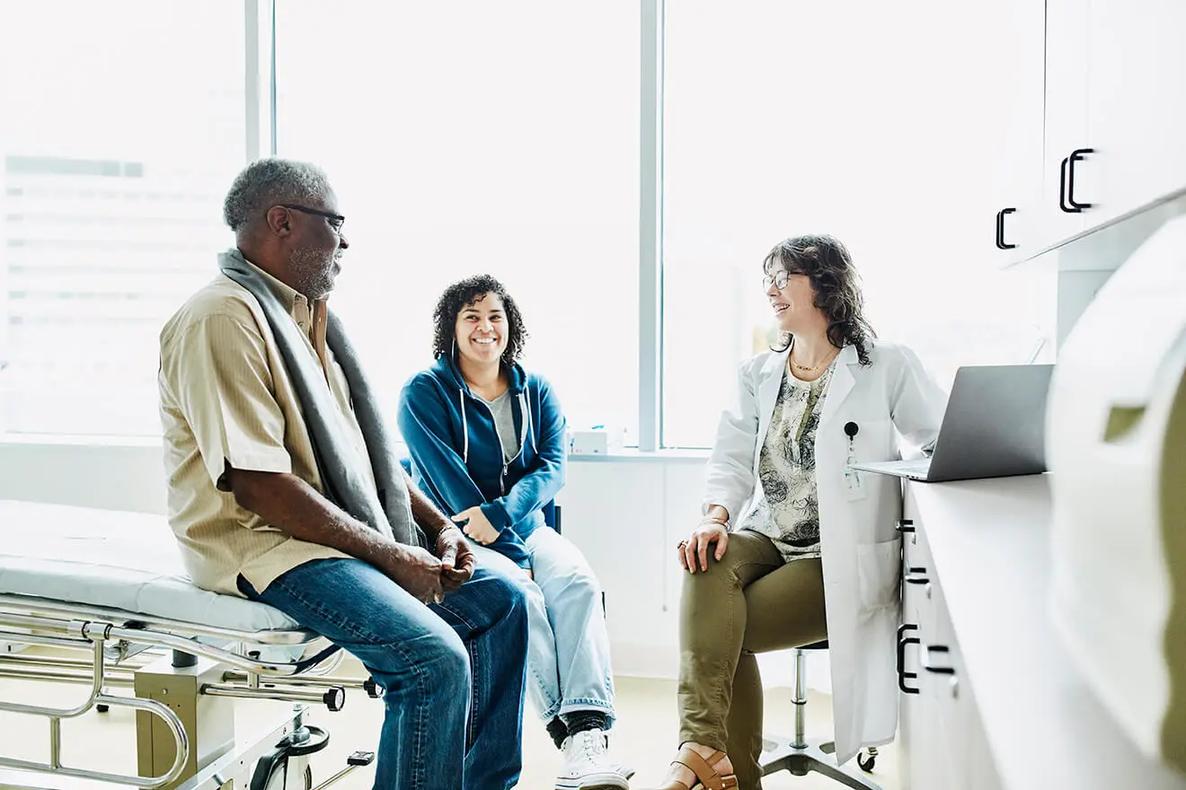 Doctor talks to patient and family member in a doctor's office