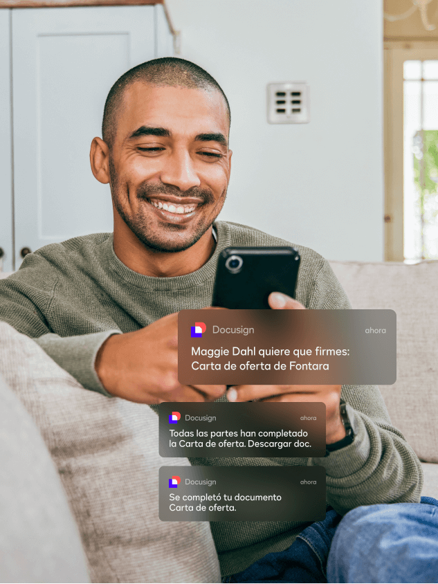 Hombre y mujer sentados utilizando un teléfono celular para leer notificaciones móviles de DocuSign eSignature  
