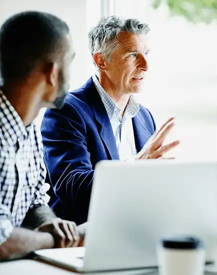 A sitting man speaking to his co-workers 