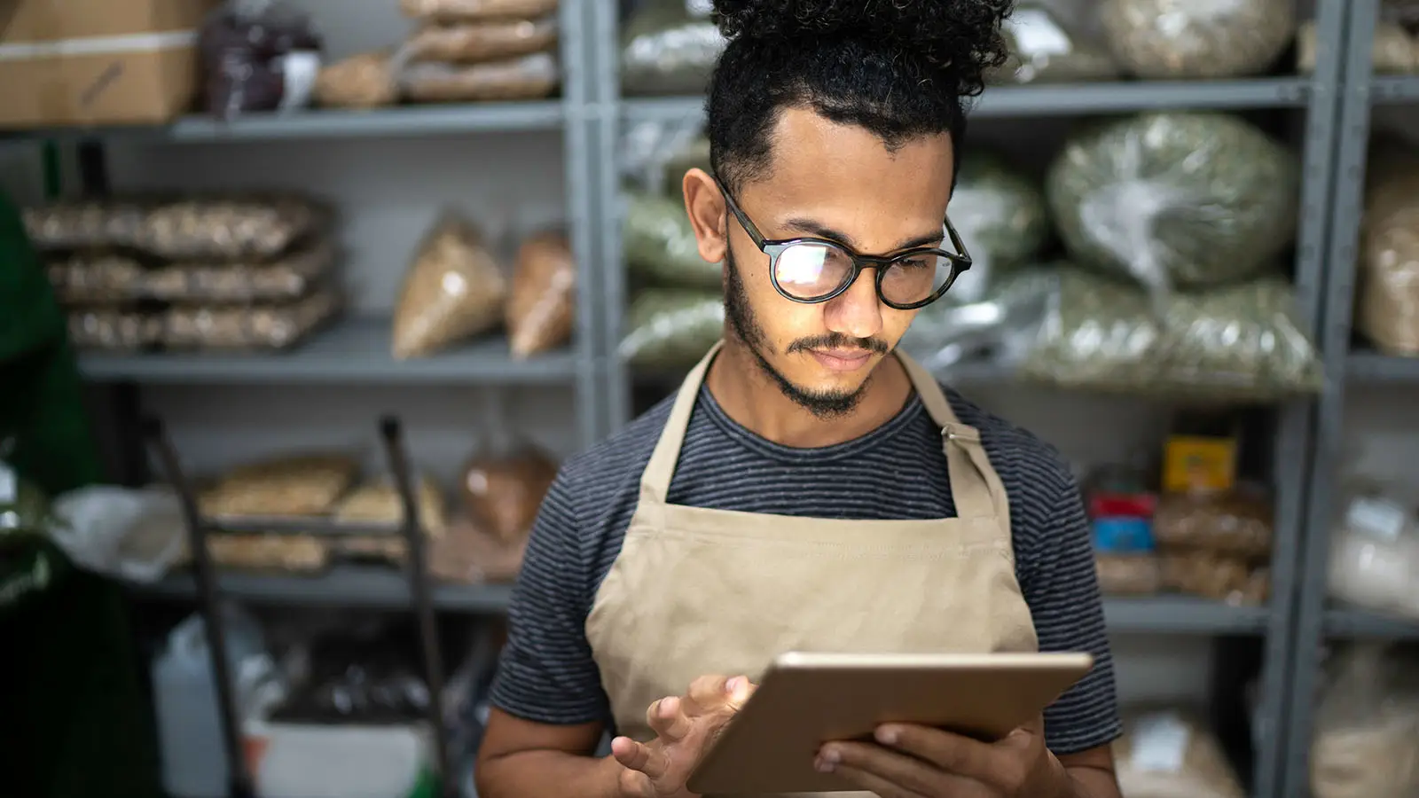 Funcionário usando um tablet na área de estoque de uma loja