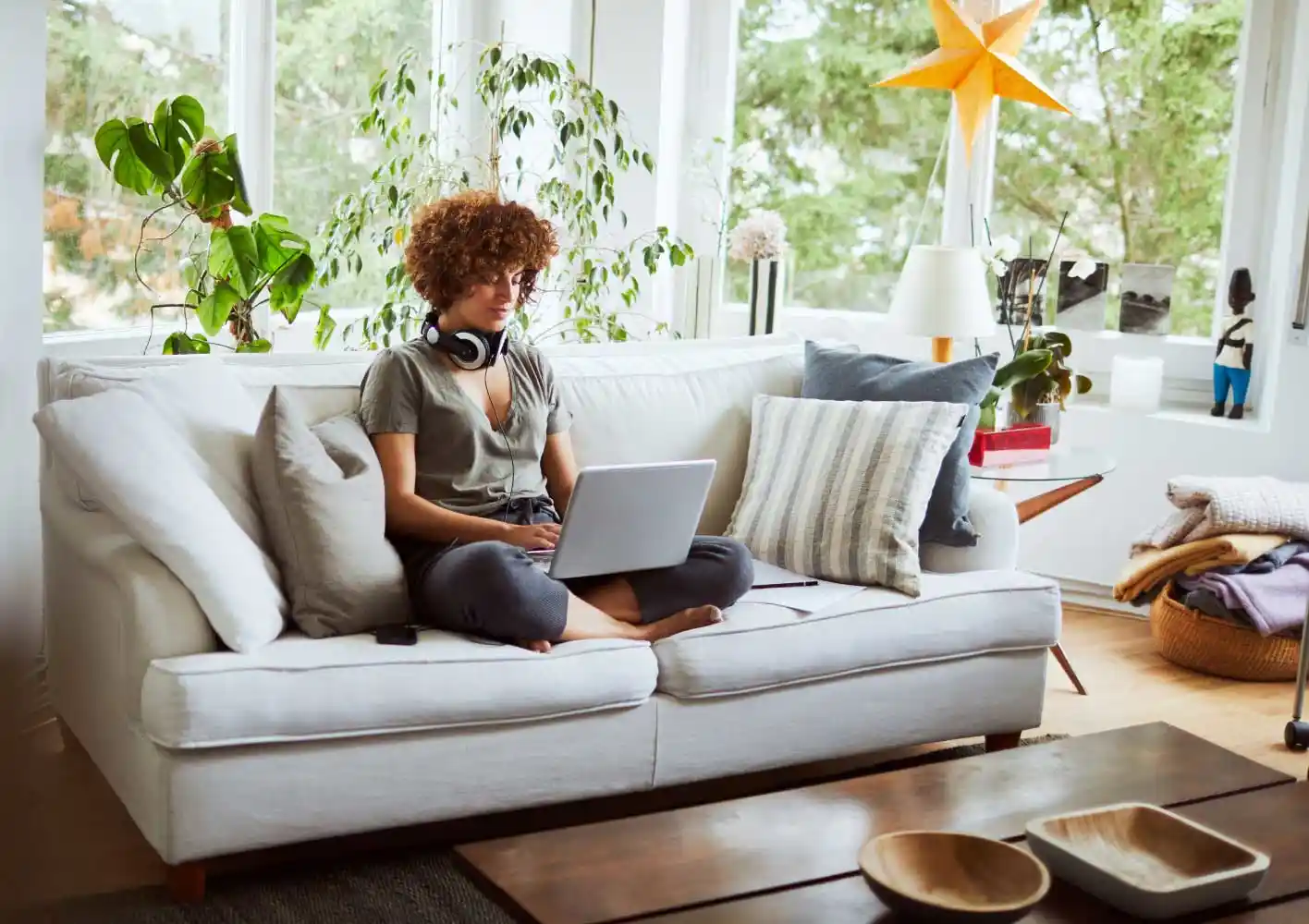 Una mujer trabaja en su laptop desde el sofá de su casa