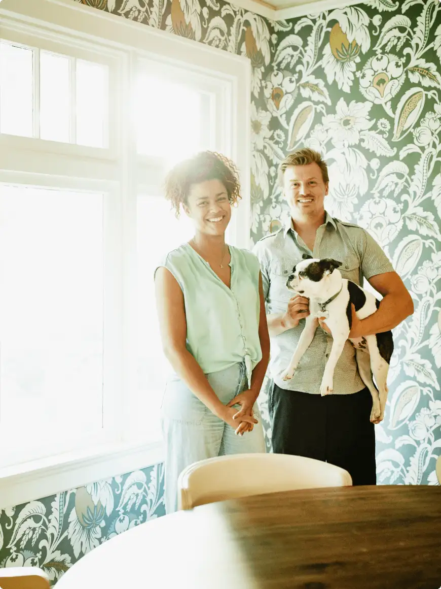 couple standing with dog inside home arranged by the British Housing Association