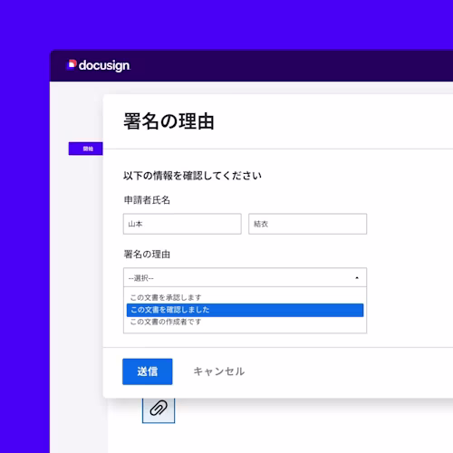 薄い青いシャツを着た男性が会議テーブルでタブレットを持っており、背景には女性とノートパソコンが見えます。
