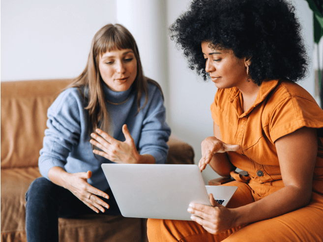 Two women collaborating on a laptop