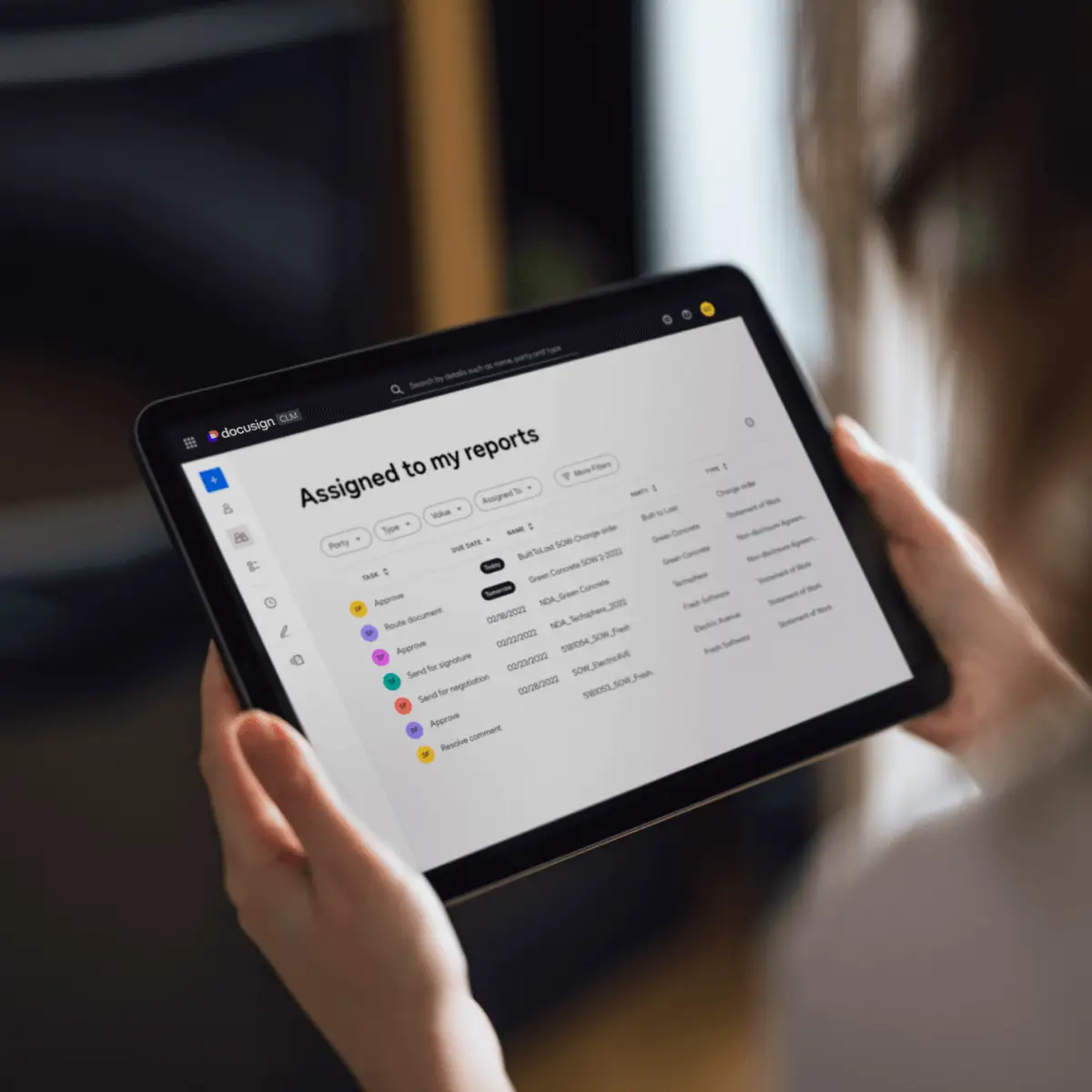 A tablet shows a dashboard of agreements in Docusign CLM with tasks and due dates