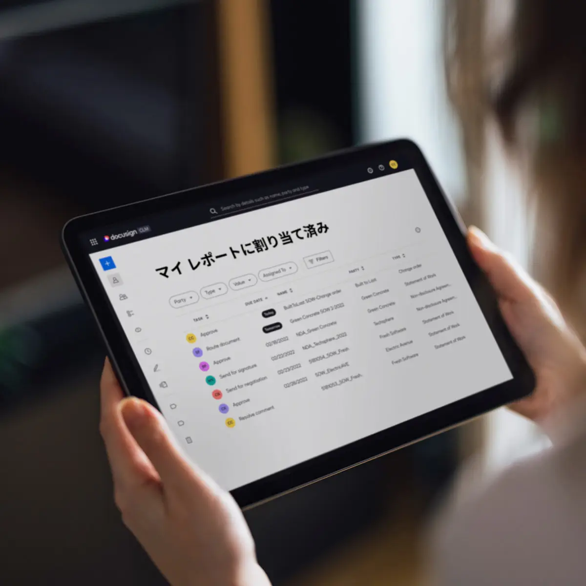 タブレットには、作業と期日が記載された Docusign CLM の契約ダッシュボードが表示されます