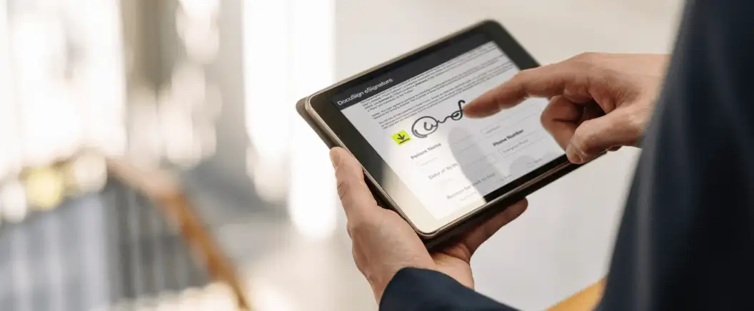 A man signs a real estate agreement in DocuSign eSignature on a tablet