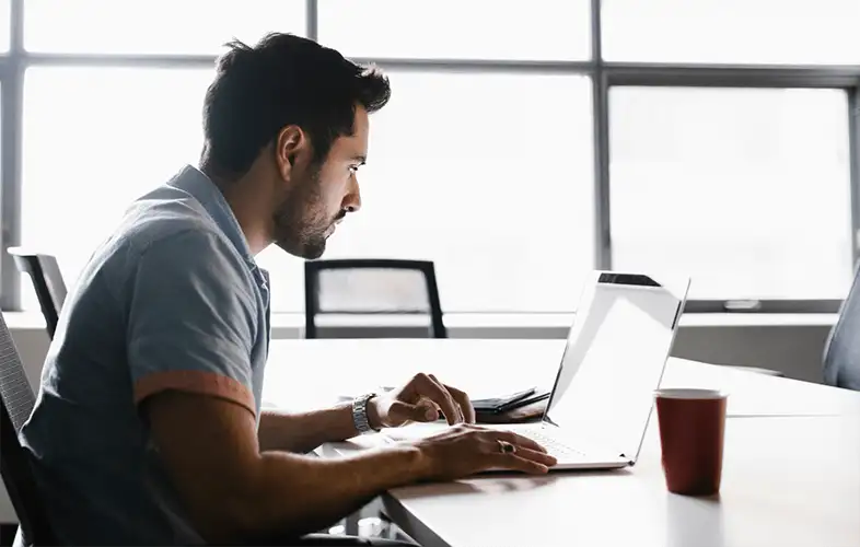 Businessman sitting on a wheelchair and holding a tablet on the workplace