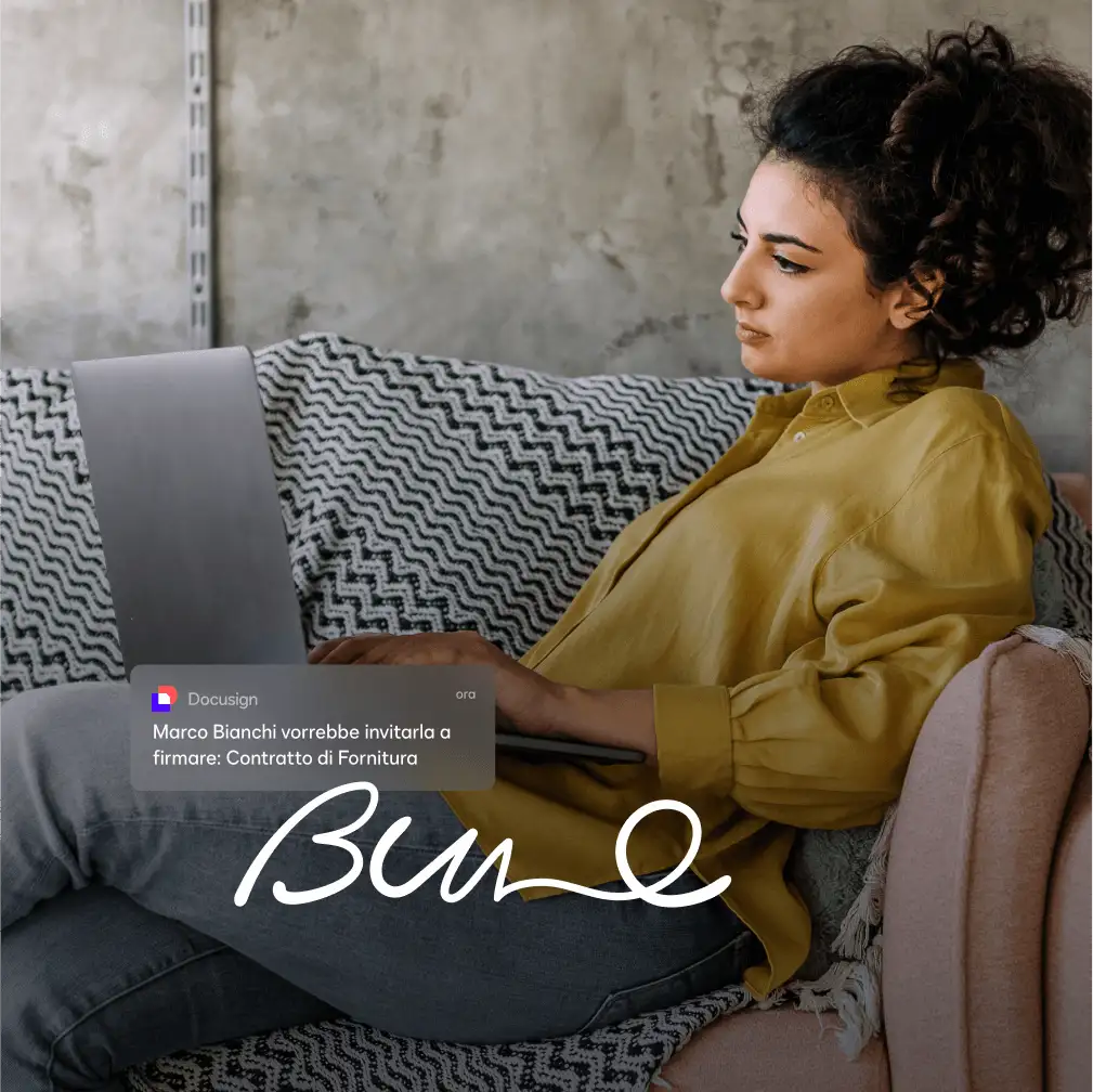 Una mujer sentada en un sofá usando su computadora portátil para firmar el acuerdo de proveedor