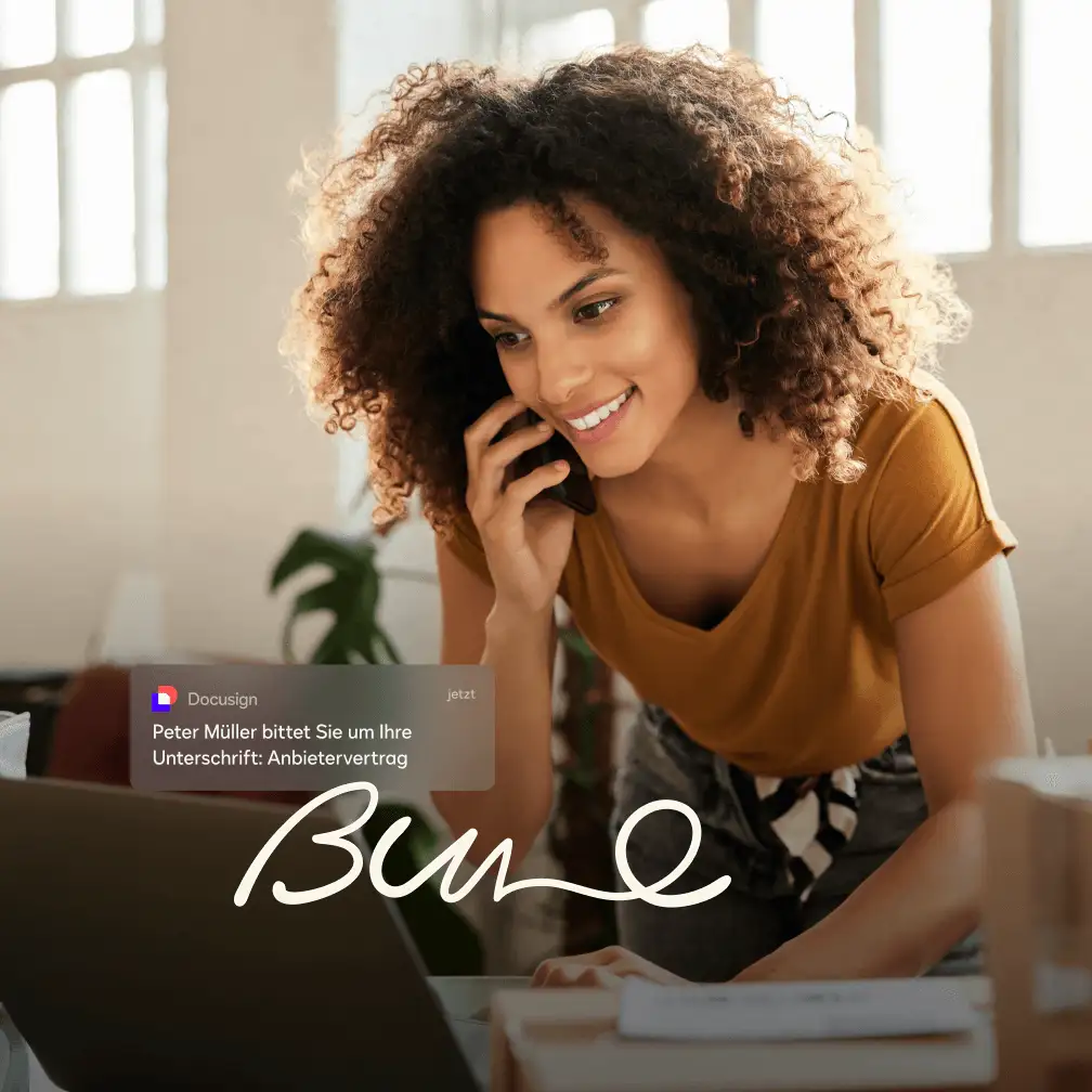 Lächelnde Frau am Telefon, die ihren Laptop zum Unterzeichnen eines Kaufvertrags benutzt