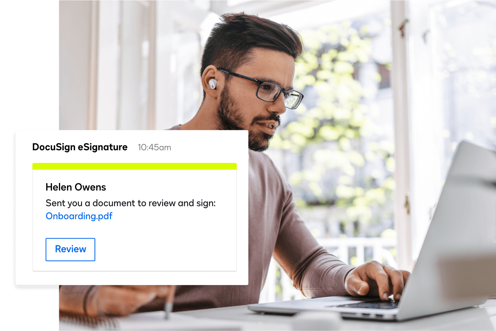 Person with glasses on their laptop with an eSignature message to review a document.