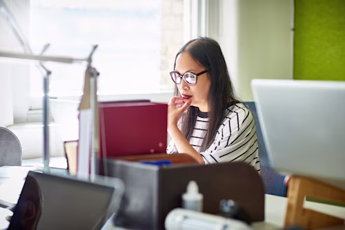 Two coworkers working on a laptop