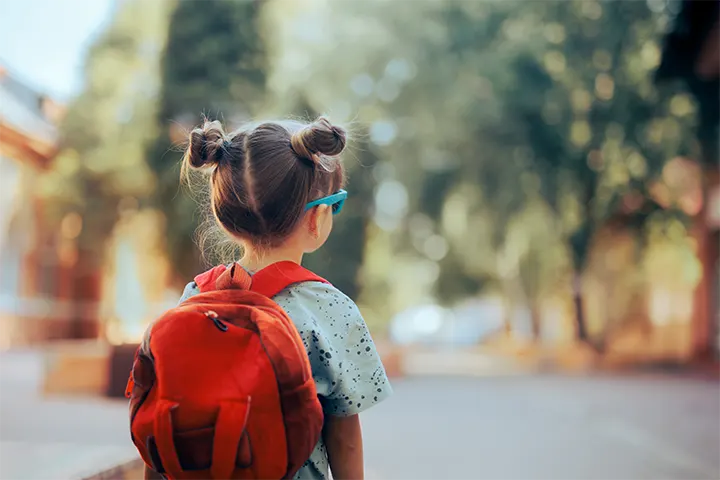 Παιδάκι με σχολική τσάντα στην πλάτη και γυαλιά ηλίου