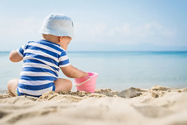 Μωράκι παίζει με κουβαδάκι στην παραλία