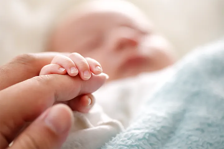 Μωρό κοιμάται και το χεράκι πιάνει το δάχτυλο του γονιού
