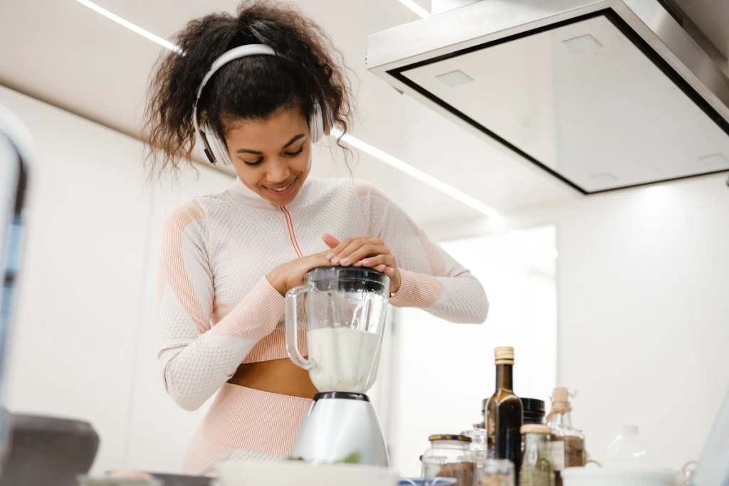 Woman with headphones making smoothie