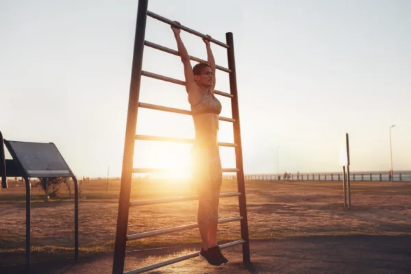 Woman hanging on bar