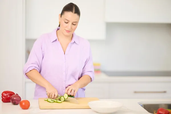 Leah Itsines chopping cucumber