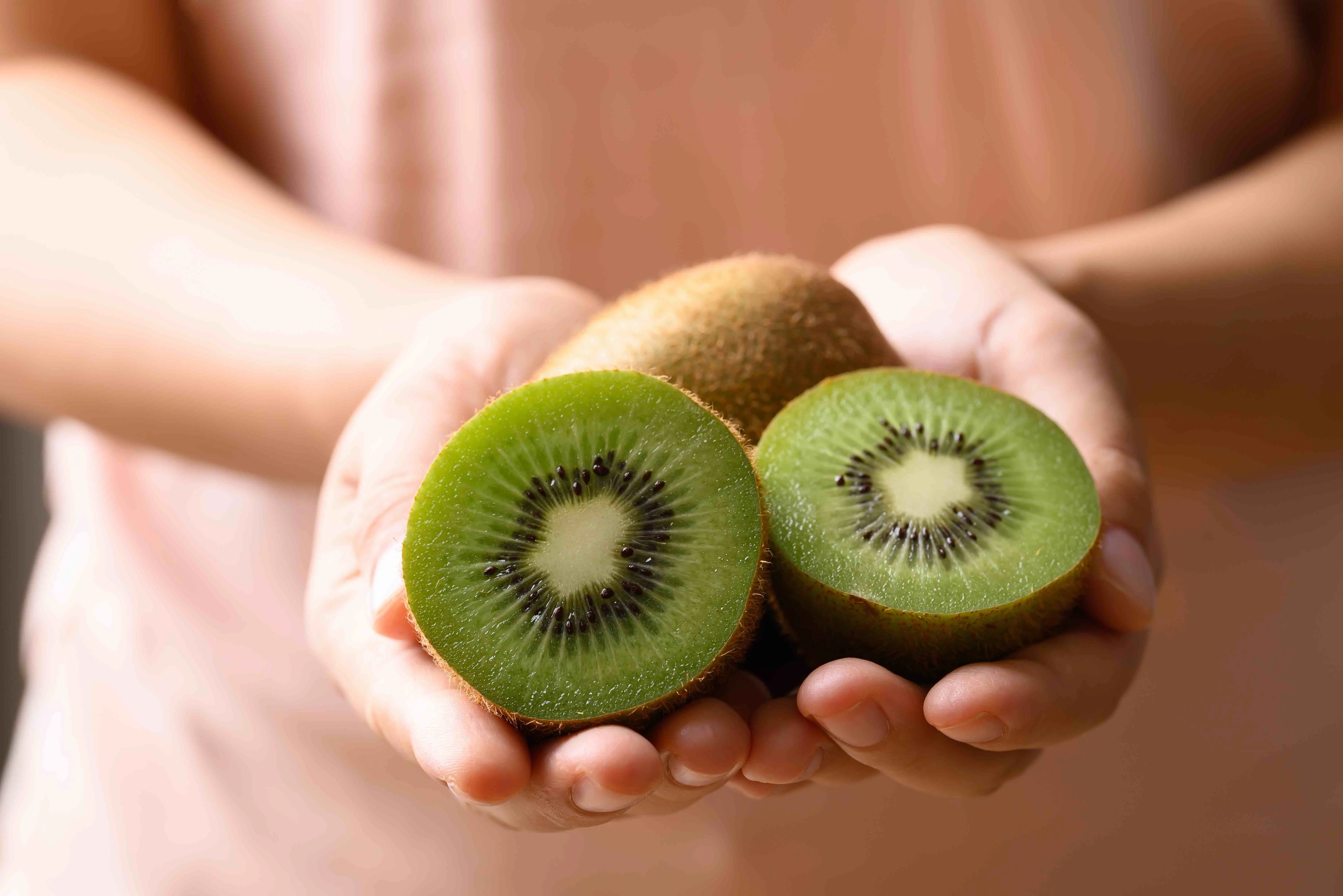 person holding kiwi fruit