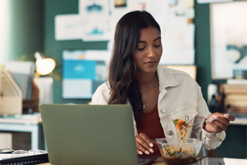 Woman eating lunch at desk 