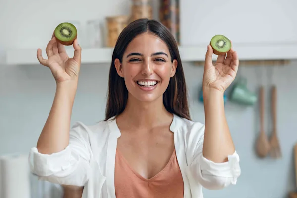 Women holding two kiwi fruit