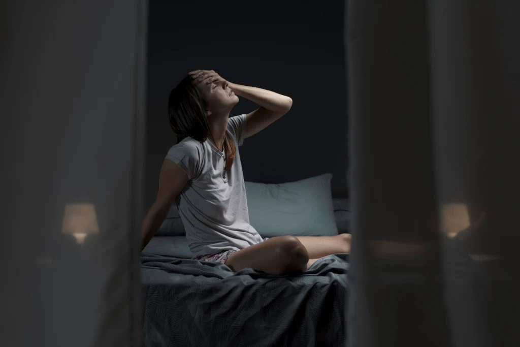 Woman tired sitting in bed