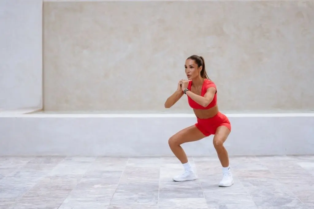Kayla Itsines bodyweight squat in red