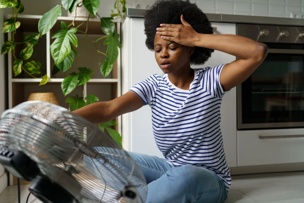 Women sitting next to fan