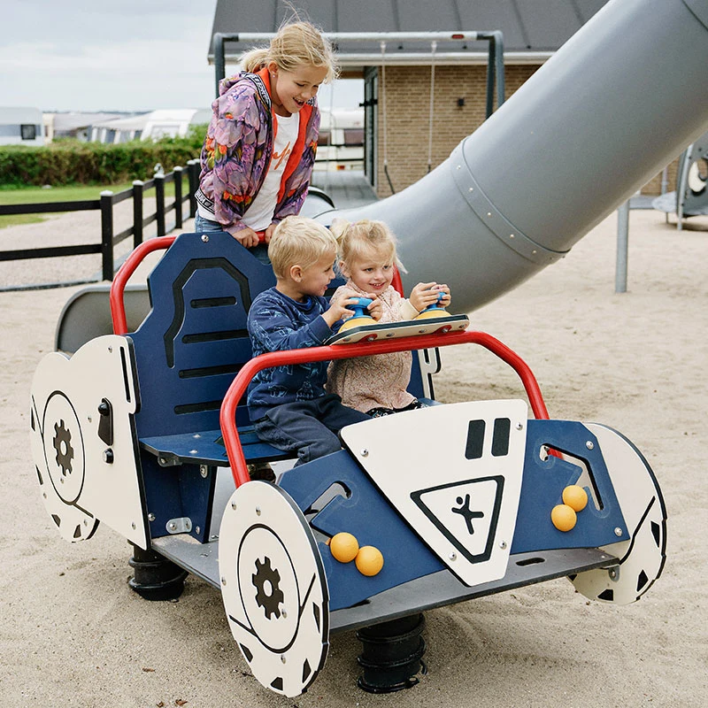 Children playing on themed playground equipment shaped like a car