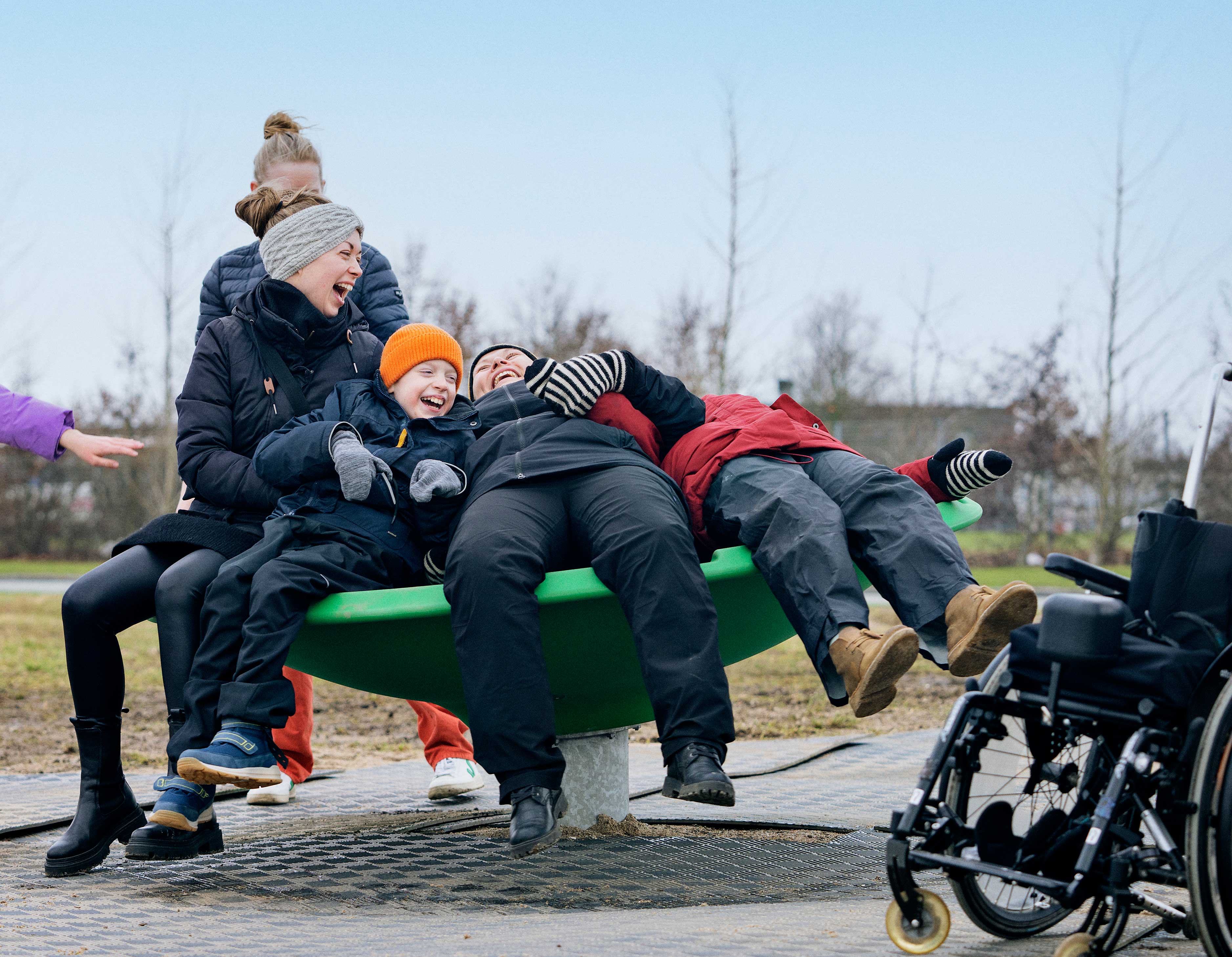 inclusive spinning playground equipment with smiling kids