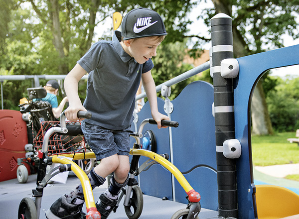 A student with physical disabilities playing on school playground equipment while navigating safely and easily