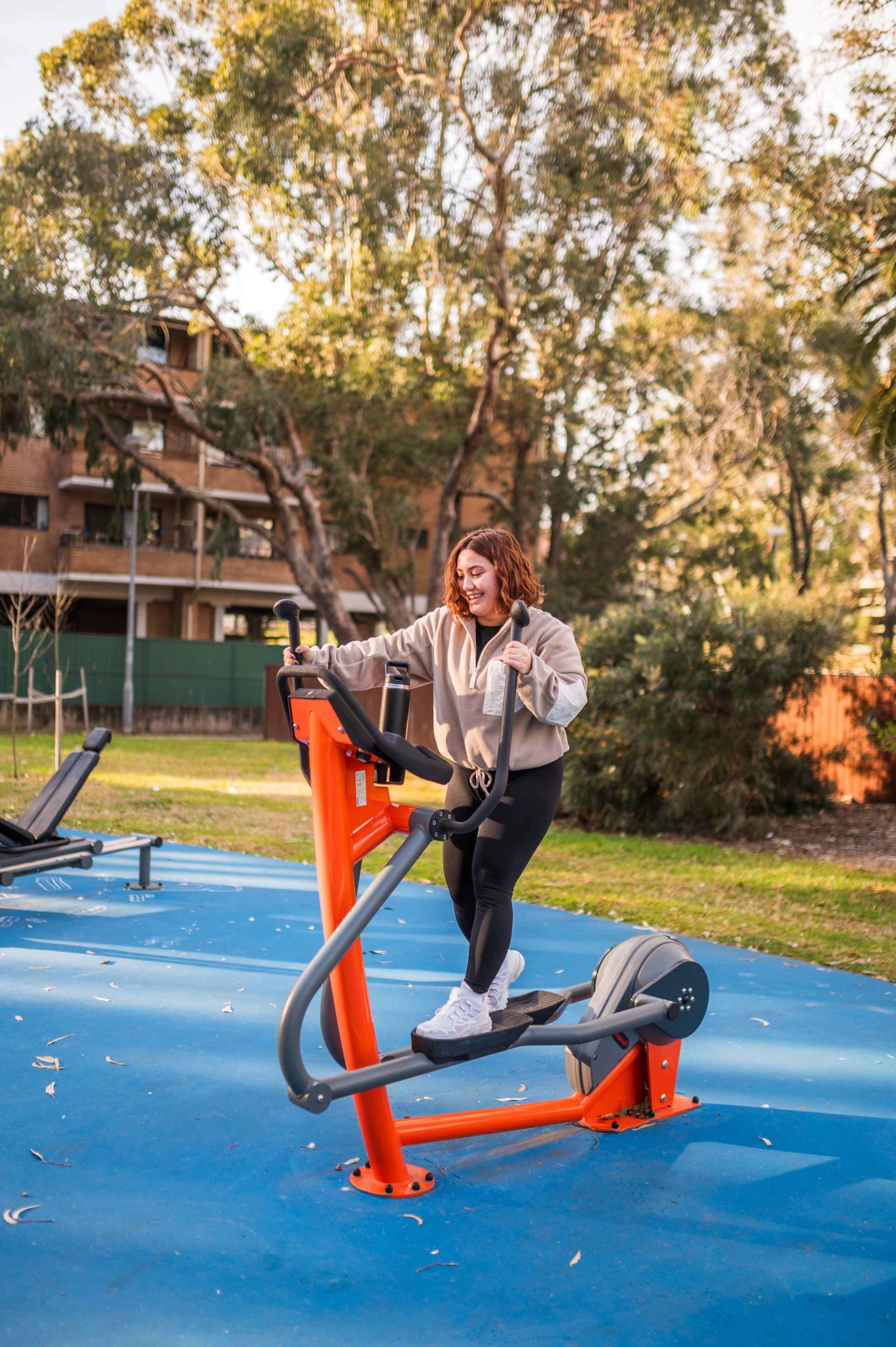 women working out on outdoor fitness equipment in Spain