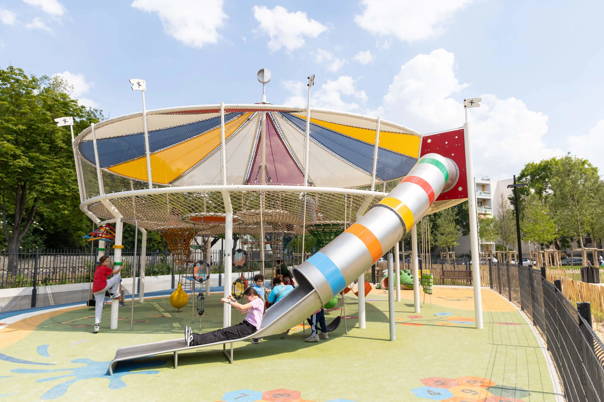 Aire de jeux sur le thème du carnaval avec des enfants glissant sur un grand toboggan