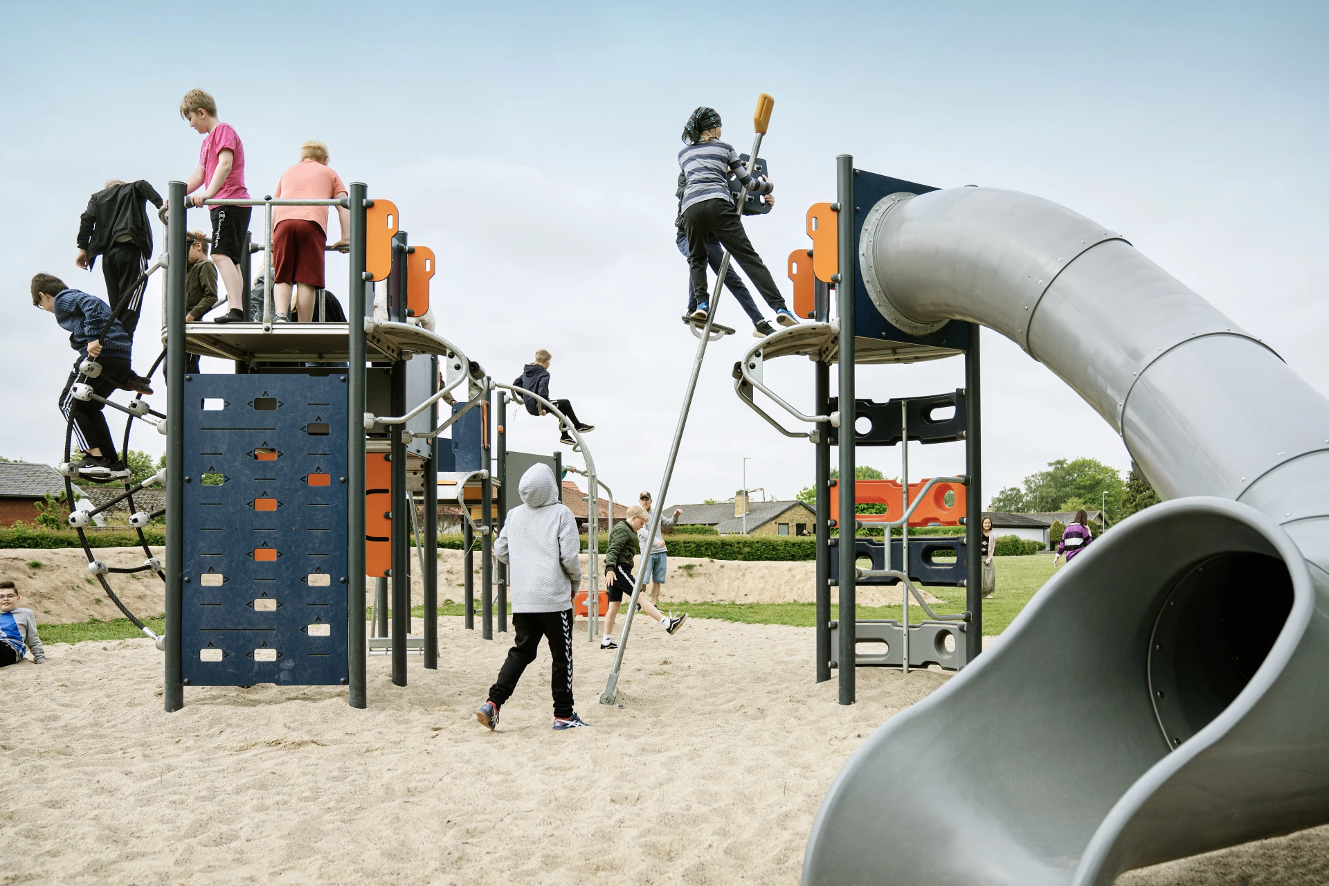 children playing on a KOMPAN playground with cliff rider