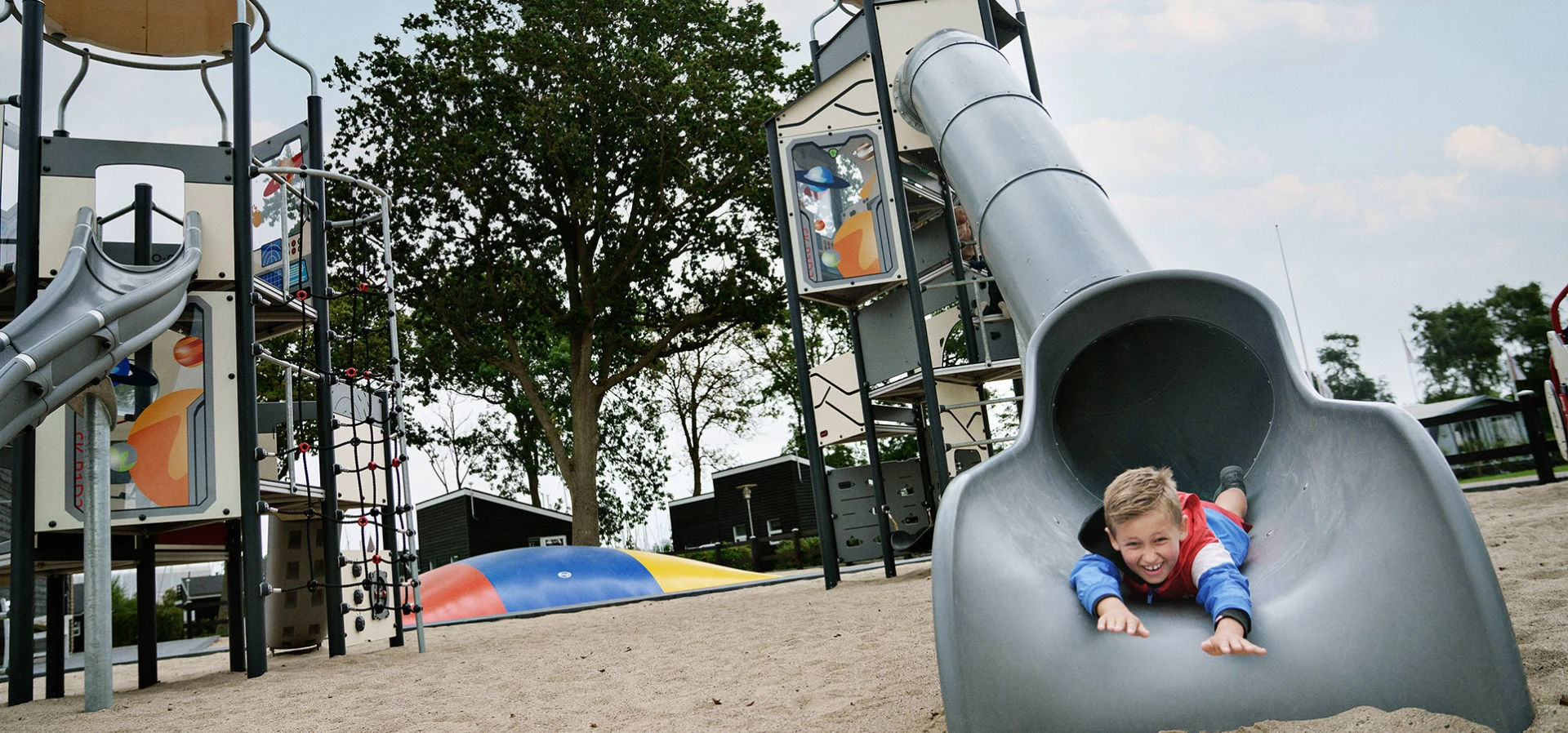 A childing sliding down a tube slide