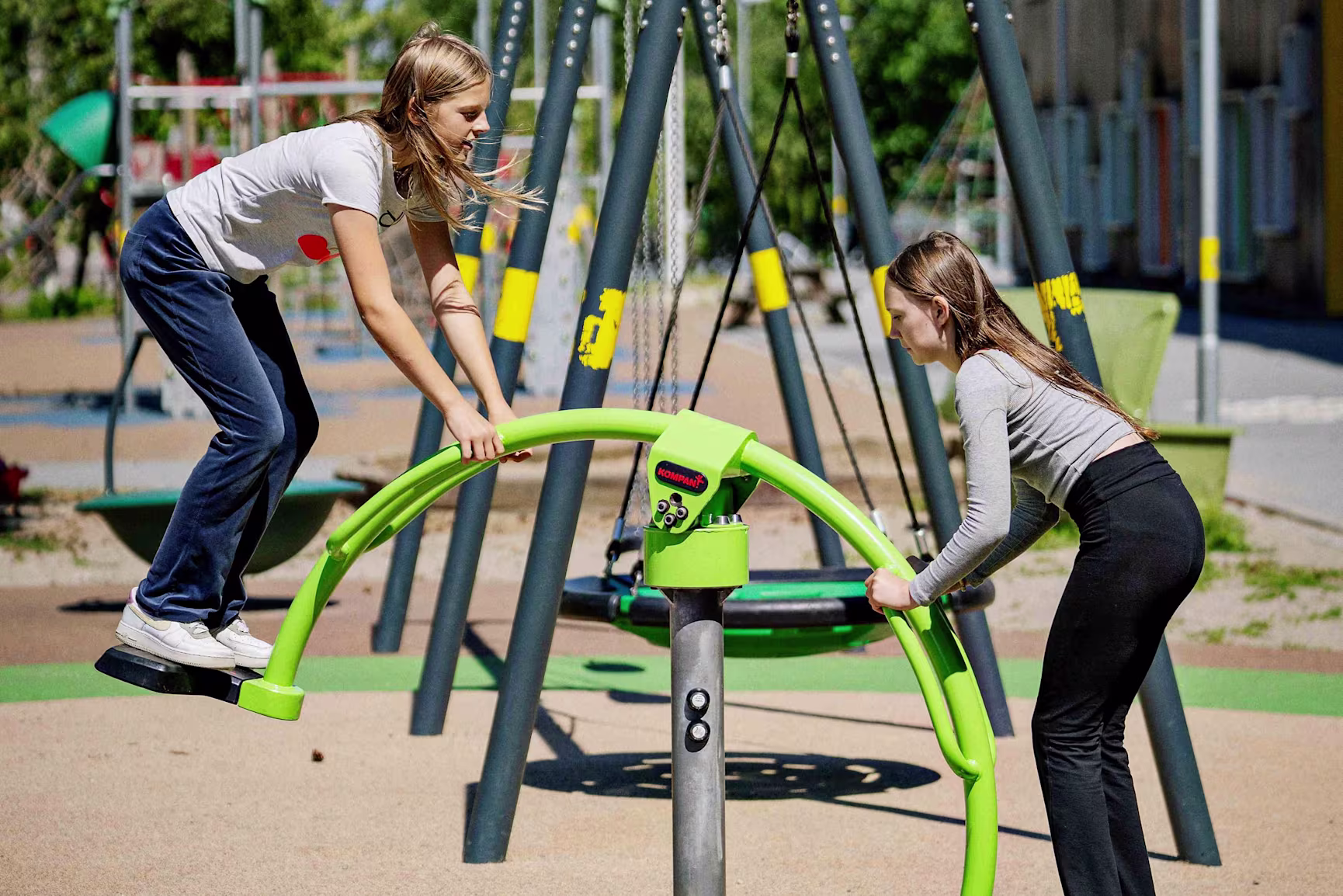 Two school children playing on playground equipment from KOMPAN.