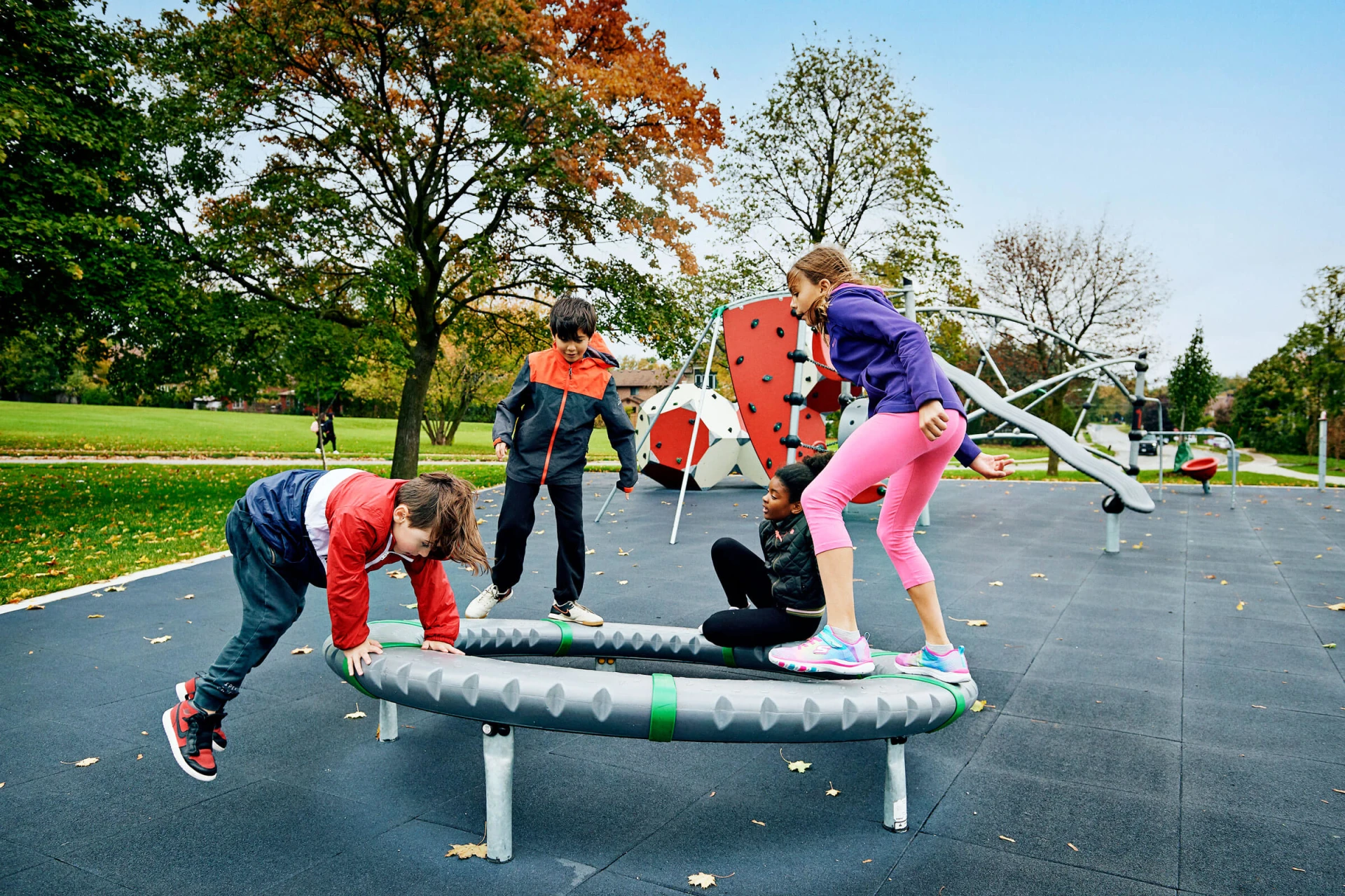 Les enfants du parc Morgan Boyle jouent sur un équipement d'aire de jeux en rotation supernova