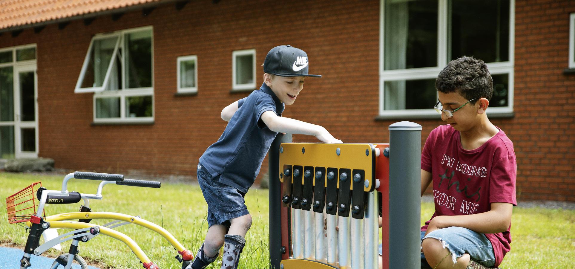 two boys playing with inclusive music play panel