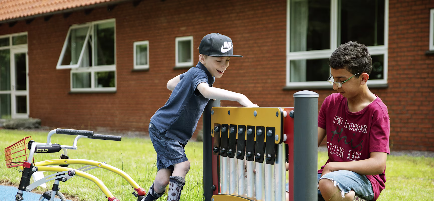 two boys playing with inclusive music play panel