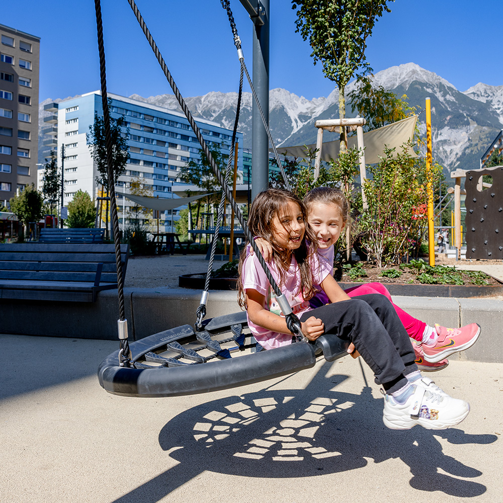 Zwei Mädchen schaukeln in Innsbruck, Österreich