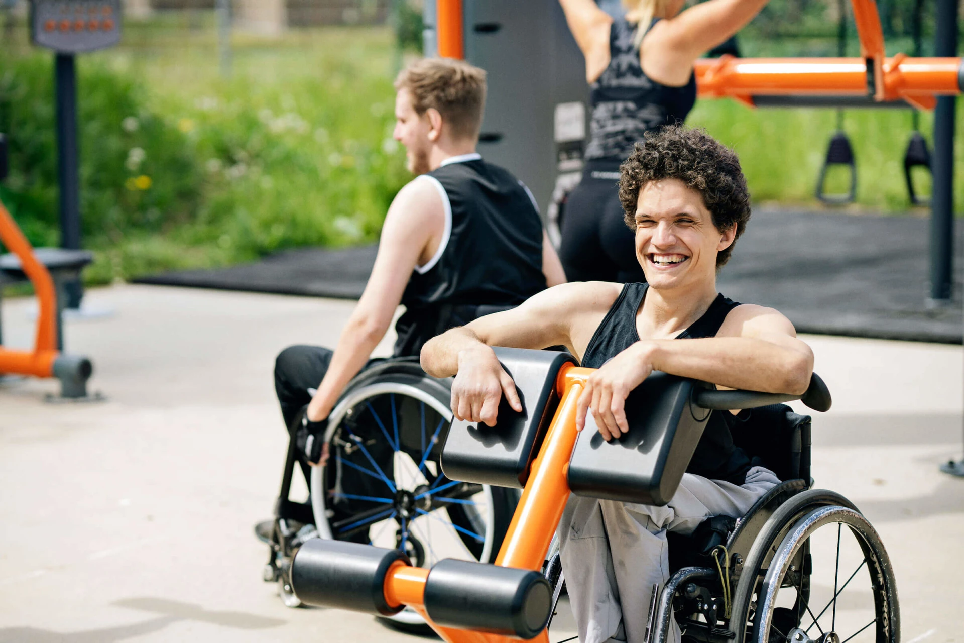 Een man in een rolstoel maakt gebruik van en inclusieve outdoor fitnessruimte