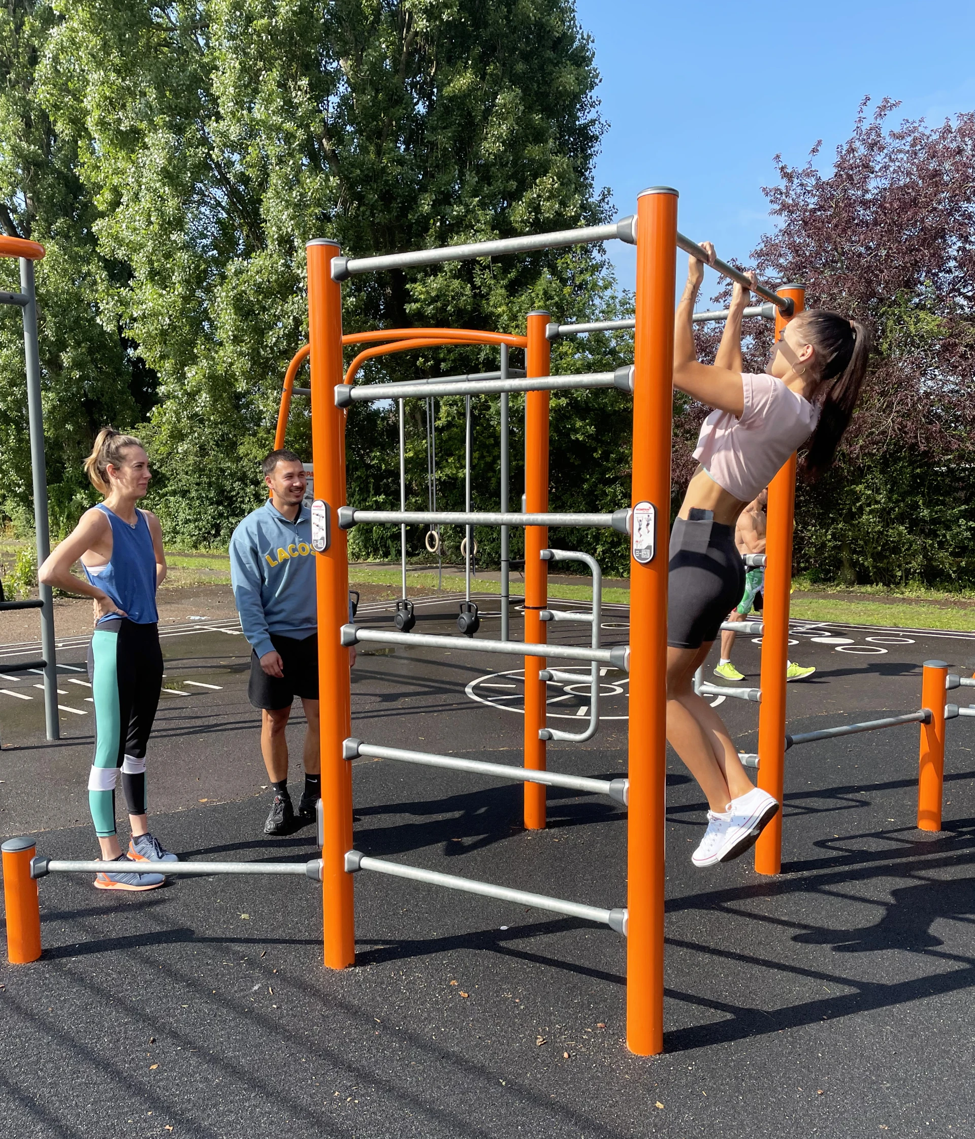 Studerende, der træner i et udendørs fitnesscenter på deres universitet.