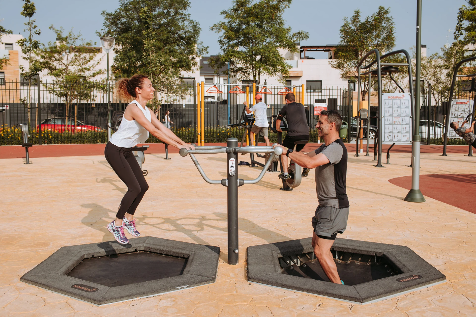 Un hombre y una mujer haciendo ejercicios en un saltador en un parque.