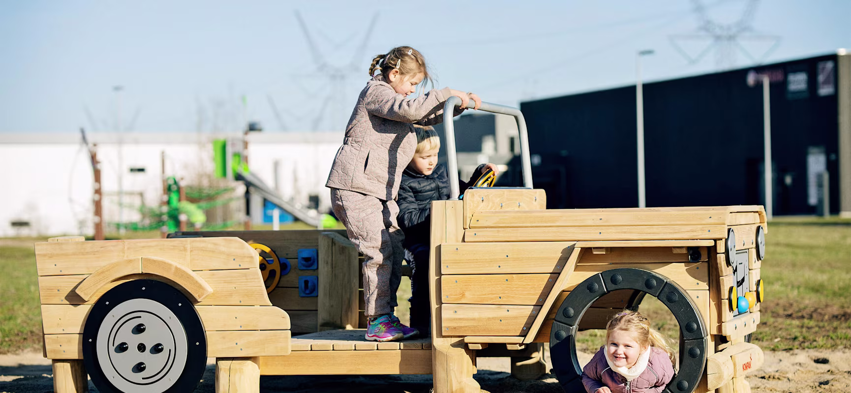 Kids playing on a themed wooden playground car