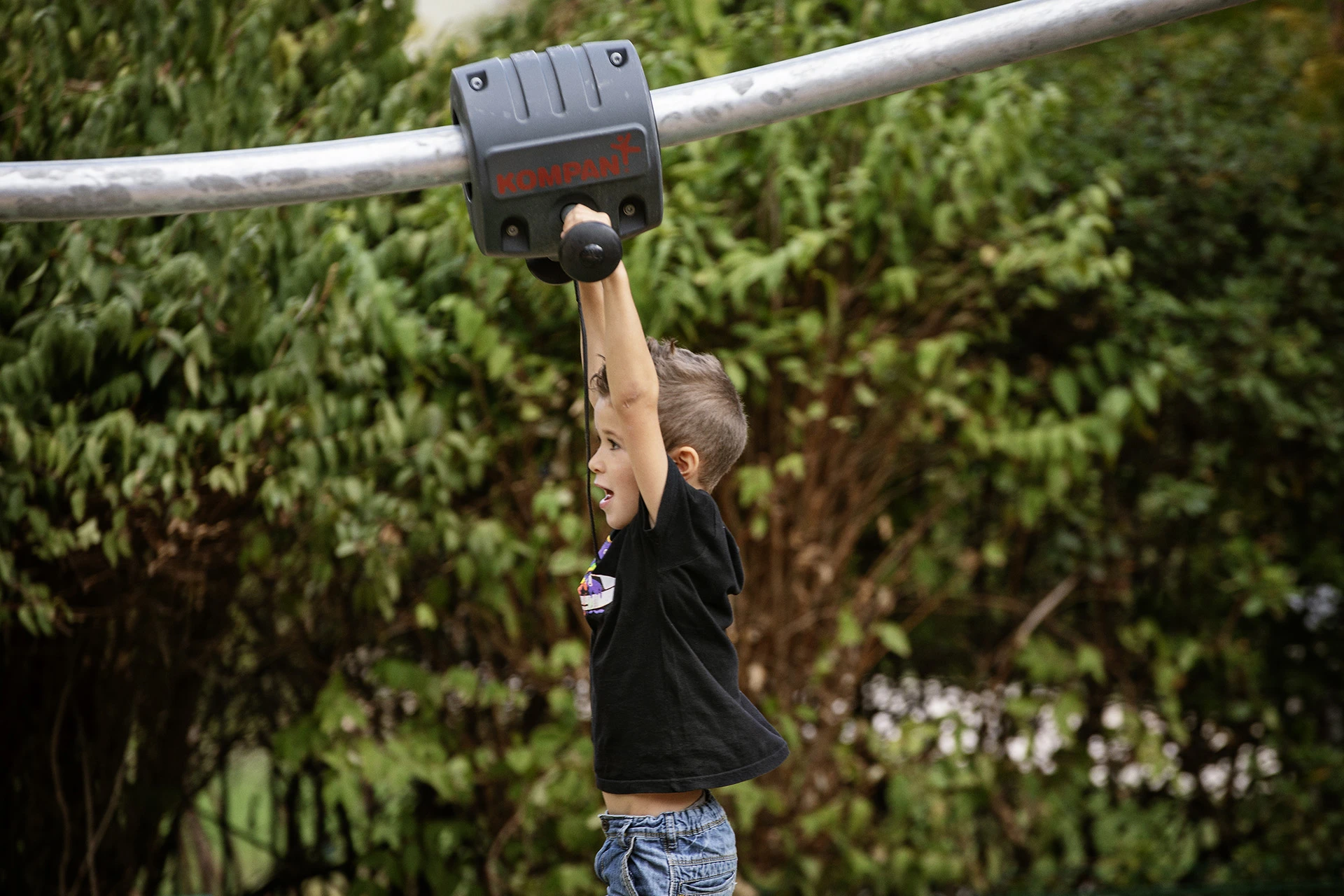 A boy gliding across a playground zipline