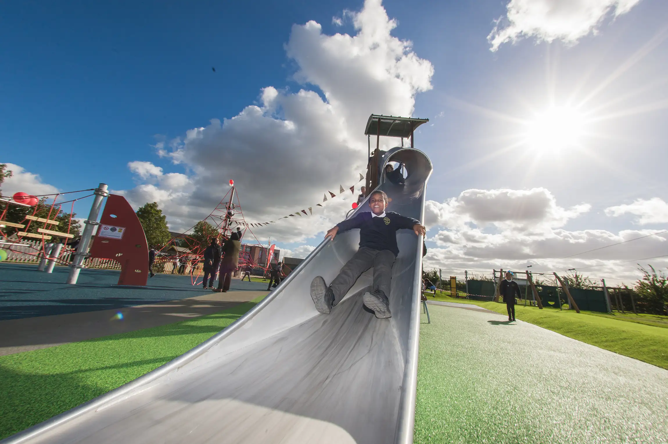 girls sliding down a playground slide on a school playground