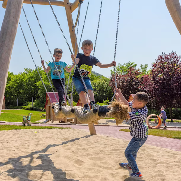 Kinder schaukeln auf einer Kokoswellen-Schaukel in Alfeld, Deutschland